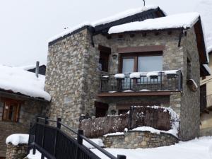 una casa de piedra con nieve encima en Casa Llop, en Espot