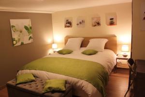 a bedroom with a large bed with two green pillows at Chambre d'hotes Antony in Fresnes