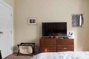 a bedroom with a dresser with a television on it at The Greenleaf House in Chicago