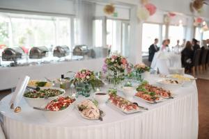 une table blanche avec des assiettes de nourriture dans l'établissement Hotelli Lepolampi, à Espoo