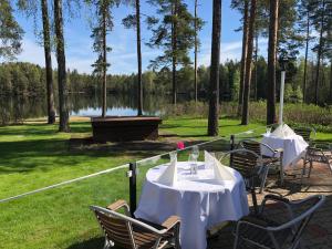 a group of tables and chairs next to a lake at Hotelli Lepolampi in Espoo