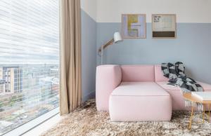 ロンドンにあるレマン ロック アパートホテルの大きな窓のあるリビングルーム(ピンクの椅子付)