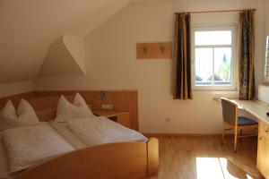 Schlafzimmer mit einem Bett, einem Schreibtisch und einem Fenster in der Unterkunft Villa Grünewald in Seis am Schlern