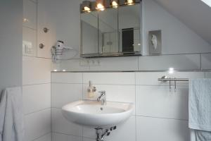 a white bathroom with a sink and a mirror at Appartement mit Aussicht in Mülheim an der Ruhr
