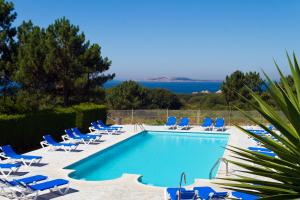 una piscina con tumbonas y una piscina en Duerming San Vicente Hotel, en San Vicente do Mar