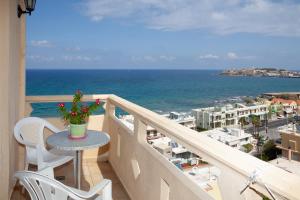 balcón con mesa, sillas y vistas al océano en Eliza Apartments, en Rethymno