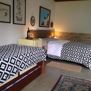 a bedroom with two twin beds and a night stand at PIccolo Borgo Antico - Rifugio del Falco in Campos do Jordão
