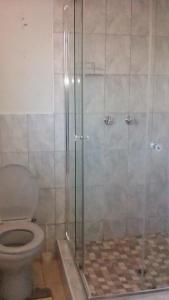 a bathroom with a toilet and a glass shower at BBN Guest House in Phuthaditjhaba