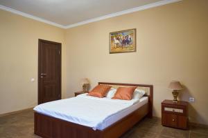 トムスクにあるHotel Extraのベッドルーム1室(白いシーツとオレンジの枕が備わるベッド1台付)