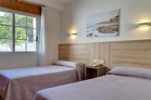 A bed or beds in a room at Duerming San Vicente Hotel