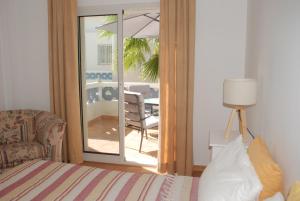 ポルト・サントにあるPorto Santo Serenity Beach Houseのベッドルーム1室(ベッド1台付)、バルコニー(テーブル付)