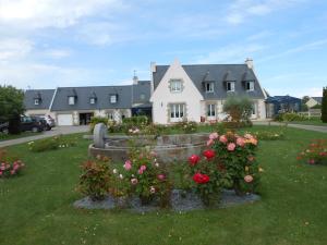 a house with a bunch of flowers in the yard at Petit Châtelet bis in Hirel