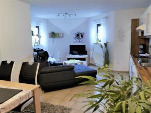 uma sala de estar com um sofá e uma mesa em Sterne-Ferienwohnung-Apartment Regnitztal em Buttenheim