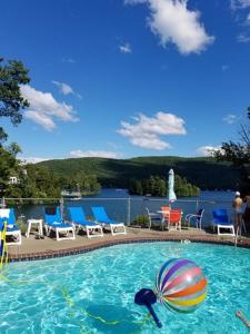 a swimming pool with chairs and a ball in the water at Boulders Resort in Lake George