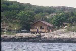 a cabin on the shore of a body of water at SAORSA CABIN in Lochinver