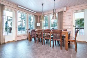 a dining room with a wooden table and chairs at Villa Puolukka in Tahkovuori
