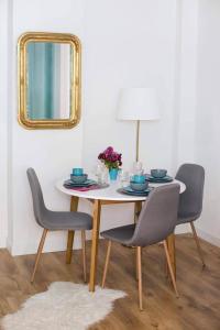a dining room table with chairs and a mirror at Flamingos Apartment ★ Free Parking ★ City Center ★ in Novi Sad