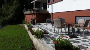 eine Terrasse mit Stühlen und einem Tisch und einem Garten in der Unterkunft Comfort and Views in Hermagor