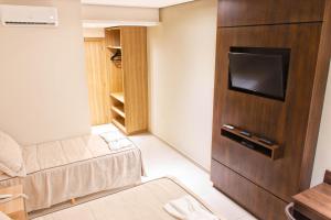 a living room with a couch and a tv in a room at Rodoserv Hotel in Pardinho