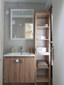 une salle de bain avec un lavabo et un miroir dans l'établissement Le Colombier Bretagne, à Louannec