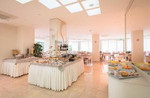 a large room with tables with food on display at Hotel Losanna in Gabicce Mare