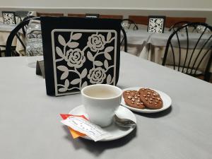 a cup of coffee and cookies on a table with a bag at Al Bosco Ficuzza in Ficuzza