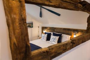 espejo que refleja una cama con almohadas azules y blancas en The Lighthouse Penthouse, Studio and Holiday Home en St Ives