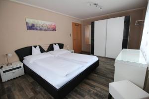 ein Schlafzimmer mit einem großen weißen Bett in einem Zimmer in der Unterkunft Ferienwohnung Stoff in Tux