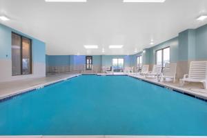 ein großer Pool mit Stühlen in einem Hotelzimmer in der Unterkunft Wingate by Wyndham Mechanicsburg in Mechanicsburg