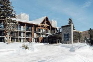 a building with snow in front of it at Entourage sur-le-Lac in Lac-Beauport