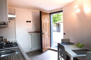 una cocina con una puerta que da a una cocina con mesa en B&B San Pellegrino Terme, en Zogno