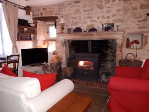 a living room with a fireplace and a white couch at La Maison de Pierre in Flavigny-sur-Ozerain