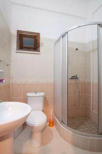uma casa de banho com um chuveiro, um WC e um lavatório. em Glaro Garden Hotel em Rizokarpaso