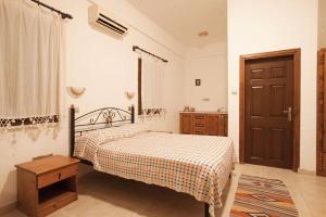 a bedroom with a bed and a wooden door at Glaro Garden Hotel in Rizokarpaso