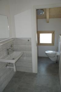 ein Bad mit einem Waschbecken und einem WC in der Unterkunft L'hôtât di loup in Courtedoux
