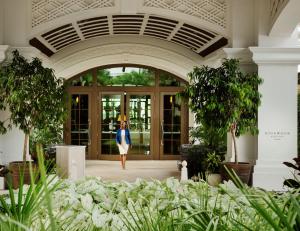 a woman walking into a building at Rosewood Baha Mar in Nassau
