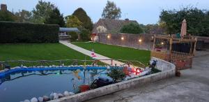 a swimming pool in a backyard with a yard at Anand Lodge in Royal Tunbridge Wells