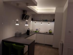 a kitchen with white cabinets and a black table at Wielicka Apartment in Krakow