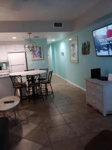 a living room with a table and chairs and a tv at Ocean Walk Resort 505 in Daytona Beach