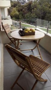 einen Holztisch mit einer Schale Obst auf dem Balkon in der Unterkunft Bosque Playa Lomas de Papudo 3 in Papudo