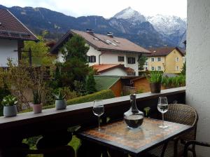 stół z kieliszkami do wina na balkonie z widokiem na góry w obiekcie Mountain View Apartment w Garmisch Partenkirchen