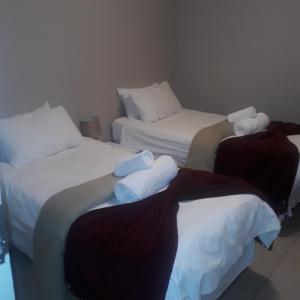 Dos camas en una habitación de hotel con toallas. en Elilo Bed and breakfast en Walvis Bay