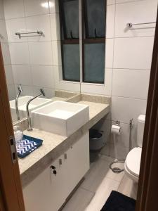 a white bathroom with a sink and a toilet at Apto luxo, Muro alto/Porto de galinhas, Polinésia in Porto De Galinhas