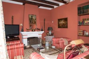 a living room with red walls and a fireplace at Hacienda La Indiana in Los Palacios y Villafranca