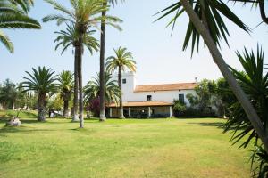 a house with palm trees in front of it at Hacienda La Indiana in Los Palacios y Villafranca
