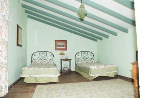 two beds in a room with blue walls at Hacienda La Indiana in Los Palacios y Villafranca +29 photos