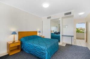 a hotel room with a bed and a desk at Madison Ocean Breeze Apartments in Townsville
