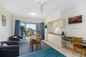 una cucina e un soggiorno con tavolo e sedie di Madison Ocean Breeze Apartments a Townsville