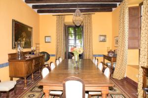 a dining room with a wooden table and chairs at Hacienda La Indiana in Los Palacios y Villafranca