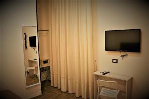 ナポリにあるB&B Da Mariaのリビングルーム(テレビ、カーテン付)